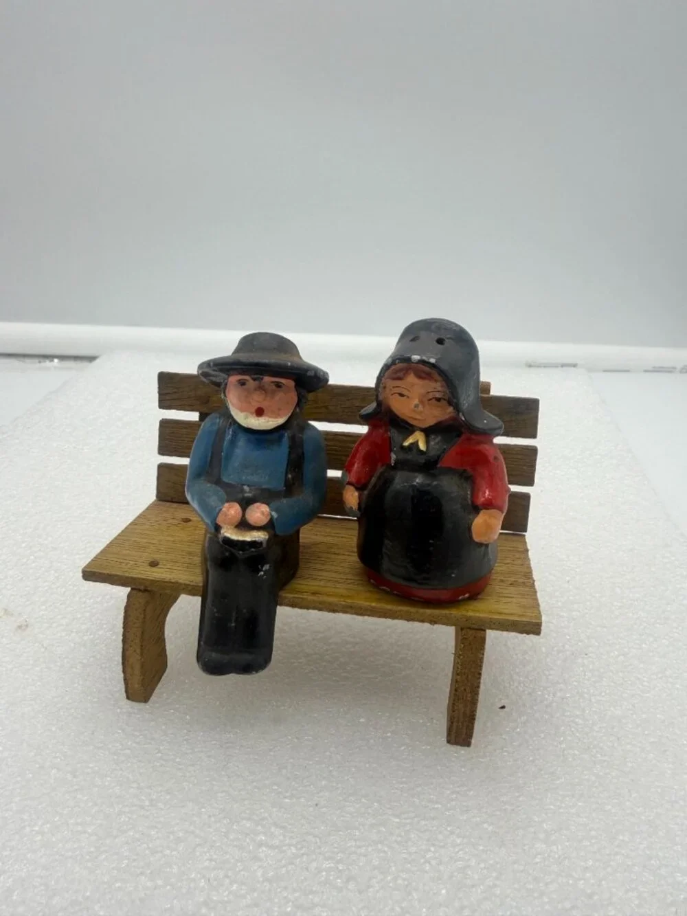 Vintage Cast Iron Amish Couple Salt and Pepper Shakers on Wood Bench